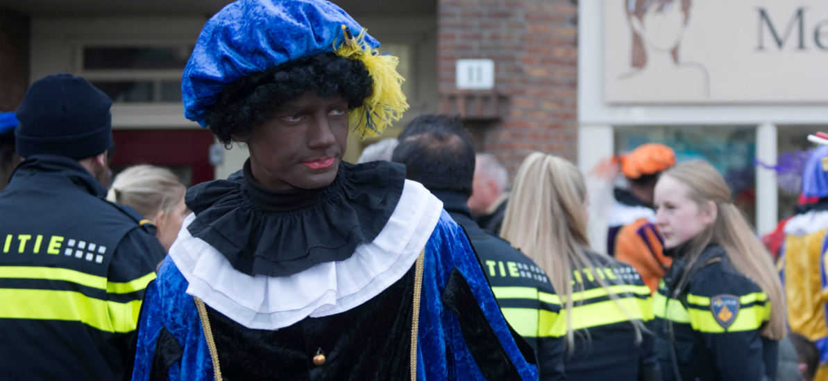 Ein Mann ist verkleidet und hat sich das Gesicht schwarz geschminkt.